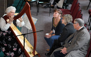 Sister Malinda Gerke plays the harp for conference participants