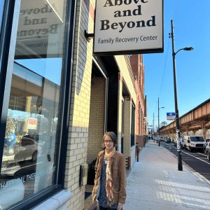 Sister Kristin Peters stands underneath the Above and Beyond Office sign in Chicago