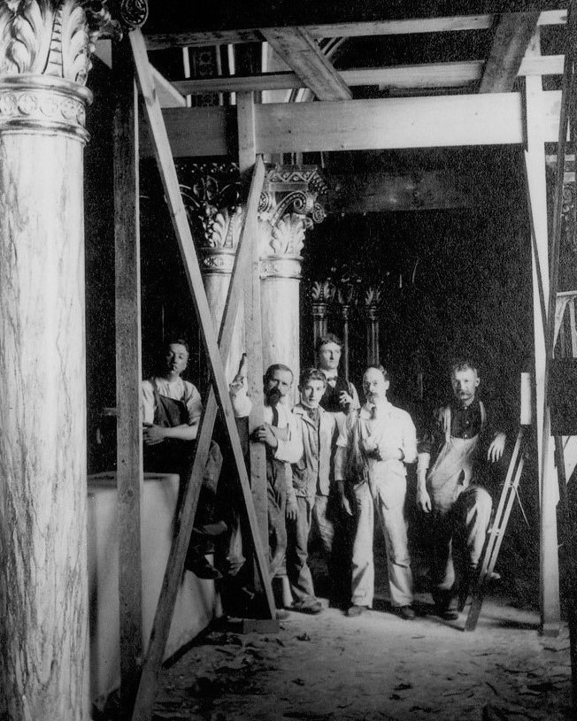 six male construction workers pose while building mary of the angels chapel in the early 1900s