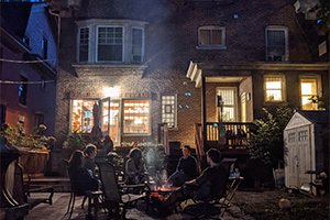 guests sitting around a bonfire at the fireplace
