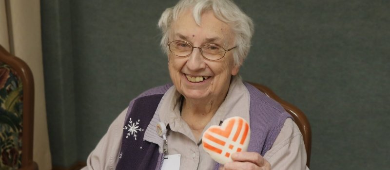 Sister Luanne Durst holding a heart shaped cookie 