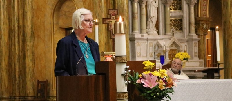 sister jolynn brehm stands in front of lectern in mary of the angels chapel addressing the crowd