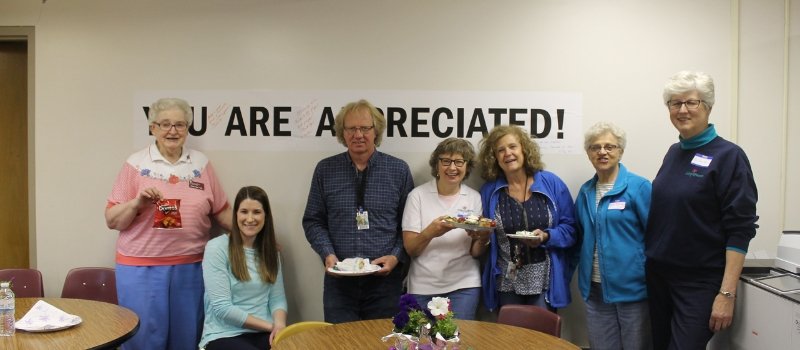 volunteers and teachers post for this photo during a team lunch