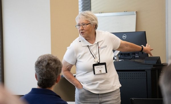 sister lucy slinger leading a canticle of creation workshop in front of a classroom