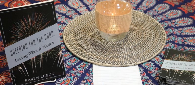 cheering for the good book sits on a table with candle