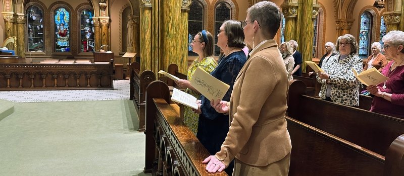 Sisters Sue, Julia and Stephanie stand in the front pew of Mary of the Angels Chapel