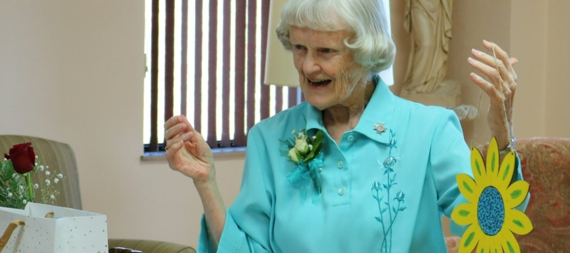 Sister Theresa Connolly is holding a yellow sunflower made out of paper