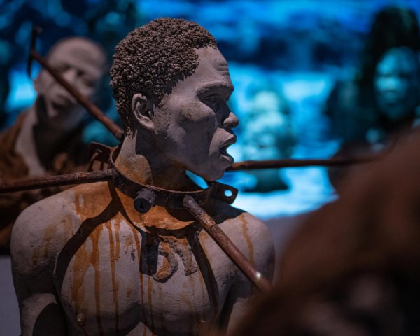 Sculpture of slave wearing rusted neck shackle at Legacy Museum in Montgomery, Alabama.