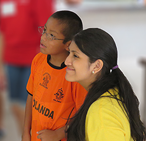 Child and volunteer happy to have glasses at Casa Hogar