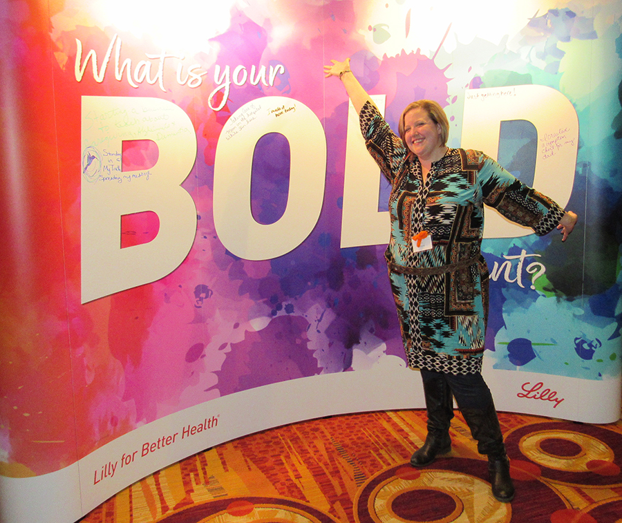 Marti Hannon poses next to a colorful wall at the CareGivers.com annual conference