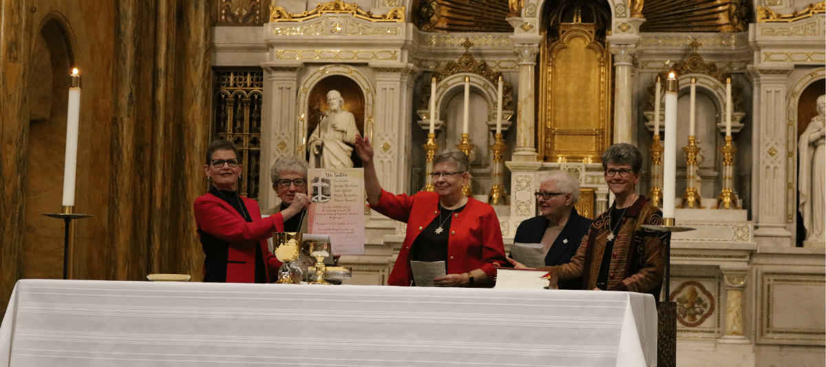 Sisters Sue Ernster, Georgia Christensen, Julie Tydrich, Marie DesJarlais and Marcia Baumert hold signed scroll