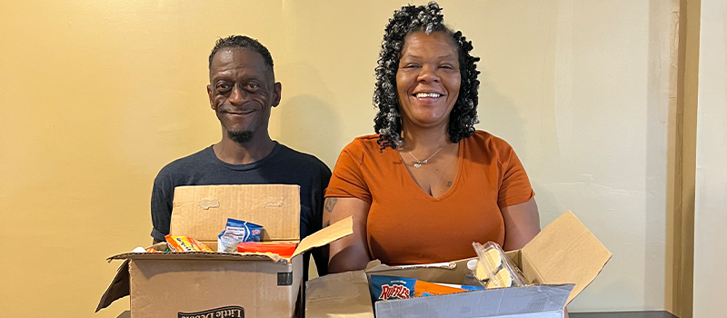 willie gaines and anita smith holding boxes of food