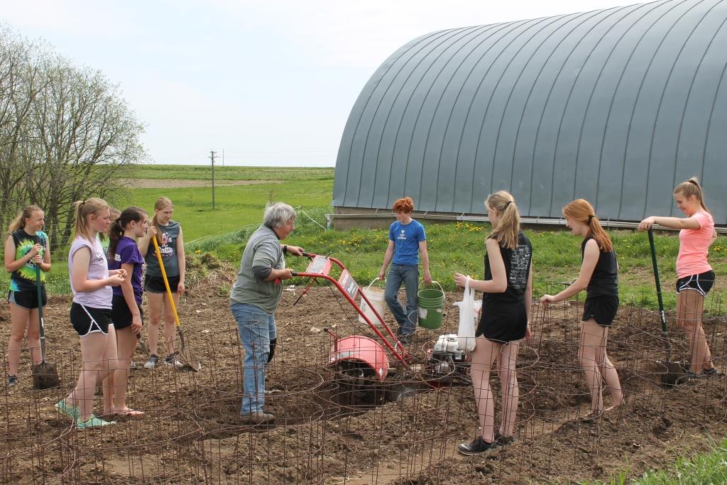 High school students spend day volunteering with Sister Lucy in organic garden