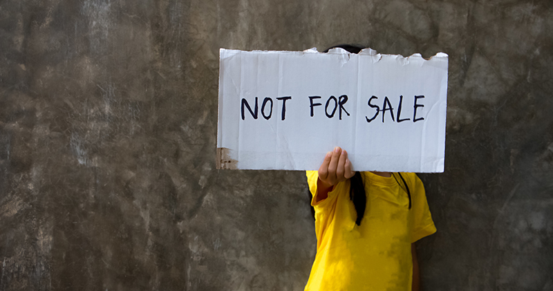 Person holding a sign that says not for sale. 