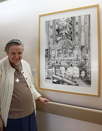 Sister Jolyce Greteman poses next to a sketch drawn in pen, that reflects her praying in the adoration chapel