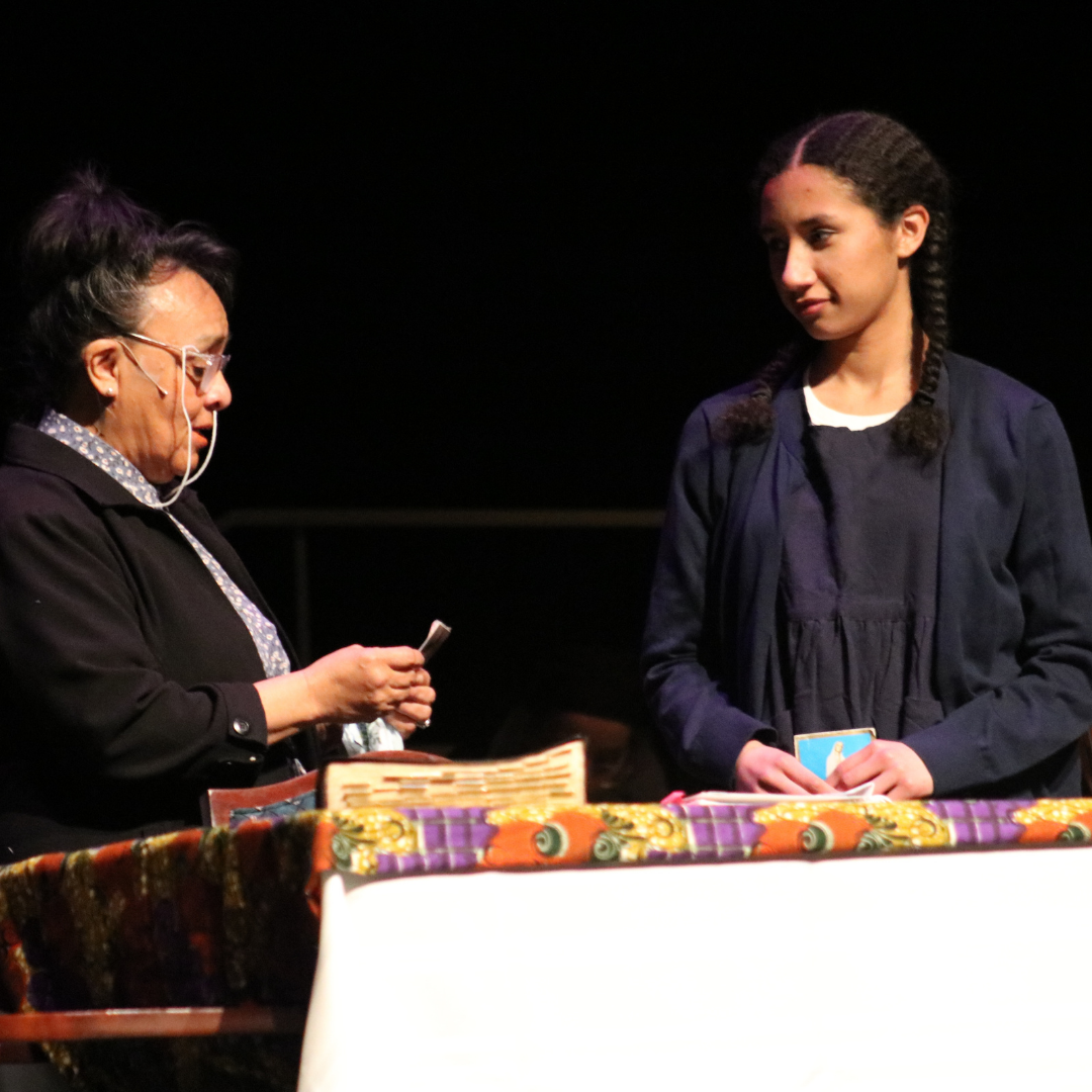 Actors on stage playing young Sister Thea Bowman and her mother in discussion at a table