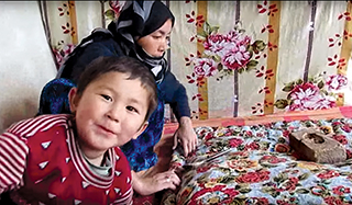 woman making duvet, boy looking at camera